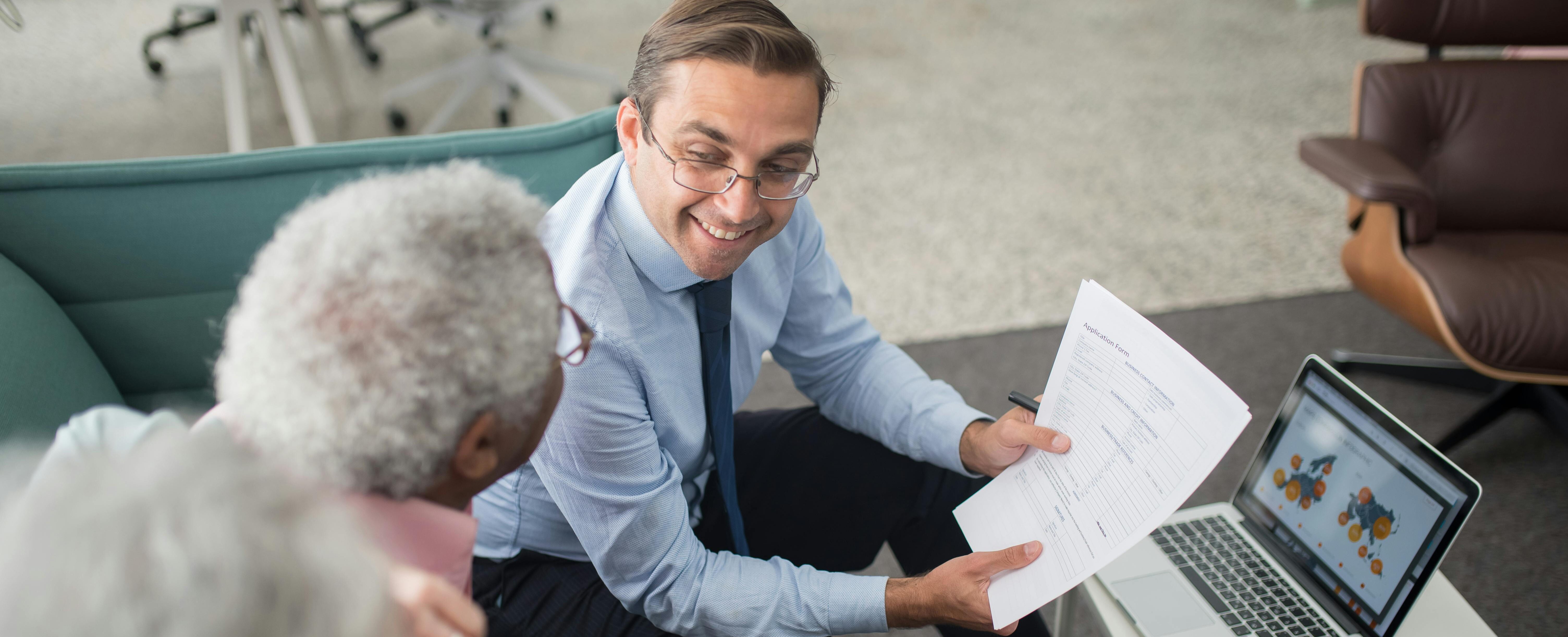 Elderly couple sitting down with a financial advisor.